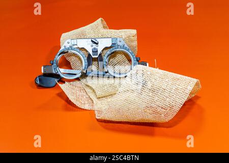 Optische Vorrichtung zur Sehprüfung an einem braunen Tuch mit orangefarbener Oberfläche Stockfoto