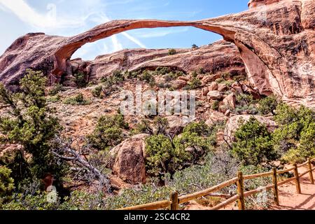 Eine Brücke über einen Canyon mit einem Zaun an der Seite. Die Brücke ist gewölbt und der Zaun aus Holz Stockfoto
