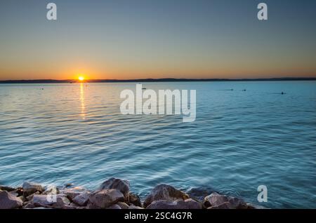 Atemberaubender Sonnenuntergang über dem Balaton, Ungarn - die Sonne untergeht anmutig über dem Balaton, Ungarns größtem und beliebtestem See, und... Stockfoto