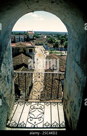 1. Aug 2020 - Kuba, Sancti Spiritus, Trinidad - Ein wunderschöner Blick, eingerahmt von einem reich verzierten Balkon, zeigt ein malerisches Dorf mit kopfsteingepflasterten Straßen und rustikalem Stil Stockfoto