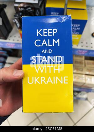 Kiew, Ukraine - 04. Februar 2025: Blau-gelbes Kästchen auf dem Regal mit Solidaritätsbotschaft für eine Sache. Bleib ruhig und stehe bei der Ukraine. Stockfoto