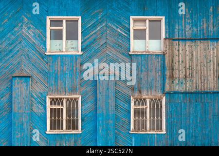 Hintergrundbild - Wand eines alten Hauses, bedeckt mit blauen Holzdielen. Stockfoto