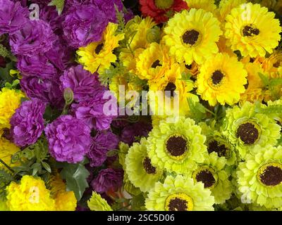Nahaufnahme von dekorativen gelben und grünen Gerbera-Blüten. Mit violetter Chrysanthemenblume. Nahtlose Hintergrundstruktur mit Blumendekoration. Stockfoto