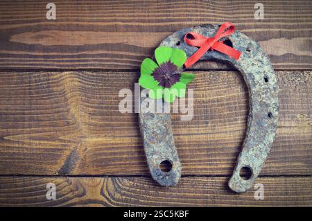 Hufeisen und Glücksklee auf hölzernem Hintergrund Stockfoto