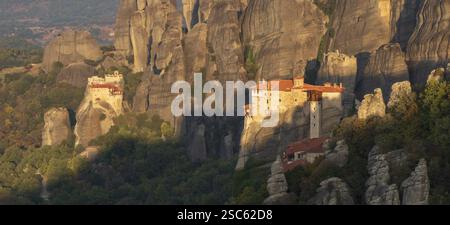 Auf den Hügeln gelegene Klöster St. Nikolaus (L) und Roussanou (R) bei Sonnenaufgang, Meteora, Trikala, Thessalien, Griechenland, Europa Stockfoto