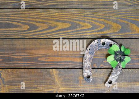 Hufeisen und Glücksklee auf hölzernem Hintergrund Stockfoto