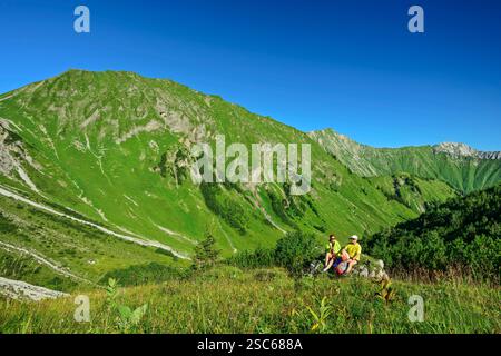 Mann und Frau wandern auf Felsen und machen eine Pause, Namlose Wetterspitze, Lechtaler Alpen, Tirol, Österreich Stockfoto