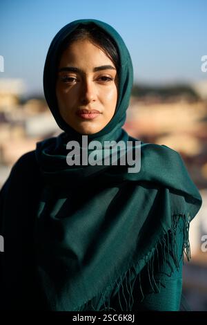 Junge muslimische Frau im Hijab, die an sonnigen Tagen auf dem Dach steht Stockfoto