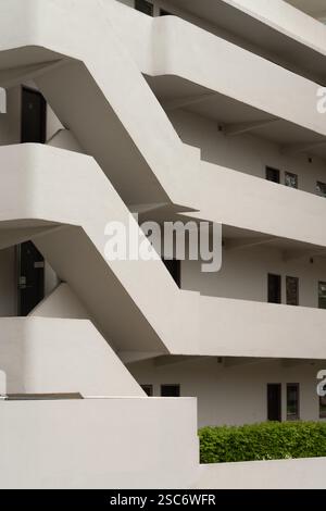 Modernistisches Apartmentgebäude mit markanten schrägen Gehwegen und Balkonen. Architektonische Details. Stockfoto