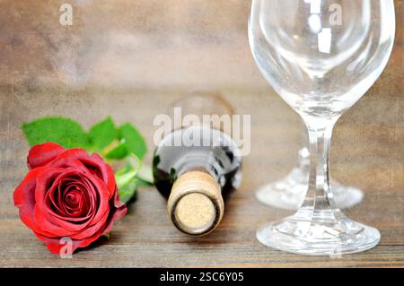 Rote Rose, zwei Weingläser und eine Flasche Rotwein auf Grunge-Hintergrund Stockfoto