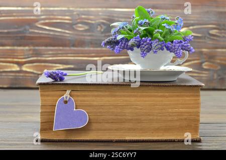 Muttertagskarte: Buch und Blumen im Vintage-Becher Stockfoto