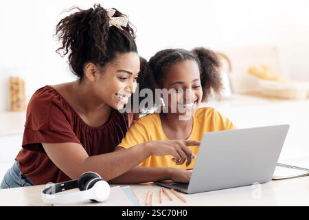 Kreative schwarze Mutter und Tochter arbeiten an Schulprojekt Stockfoto