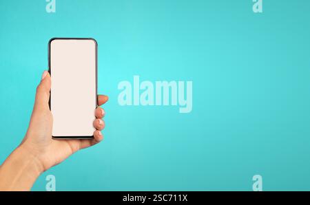 Weibliches Hand-Holding-Telefon Mit Weißem Bildschirm Auf Blauem Hintergrund Stockfoto