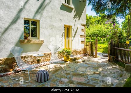 Terrasse des rustikalen alten Bauernhauses und Blick auf den Garten am sonnigen Sommertag, Milecice Dorf, Niederschlesien, Polen Stockfoto