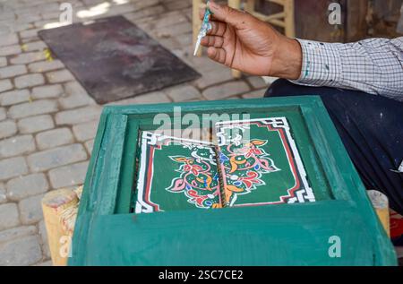 Eine Hand, die seine Arbeit in einem dekorativen Holzfenster in einem Kunsthandwerk in Marrakesch zeigt Stockfoto