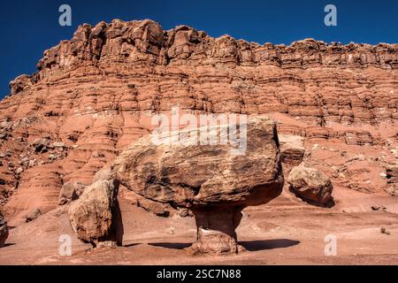 Ein großer Felsen sitzt auf einem Hügel. Der Felsen ist groß und hat eine einzigartige Form. Der Hügel ist felsig und hat viele Felsen Stockfoto