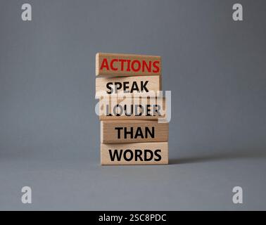 Taten sprechen lauter als Wörter. Holzblöcke mit Worten Aktionen sprechen lauter als Worte. Schöner grauer Hintergrund. Business and Actions conc Stockfoto
