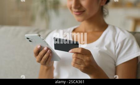 Glückliche lächelnde sorglose indische Frau Arabische weibliche Käuferin geben Sie sichere Nummer der Kreditbank Kartenbank Online-Handy-Shopping ein Stockfoto