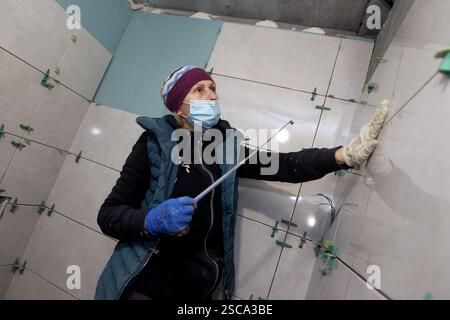 DNIPRO, UKRAINE - 5. FEBRUAR 2025 - Ein Mitglied des ersten ukrainischen Damenbaubataillons arbeitet an der Restaurierung einer Wohnung in einem durch russische Bombenangriffe beschädigten Mittelgebäude, Dnipro, Ostukraine (Foto: Mykola Miakshykow/Ukrinform) Stockfoto
