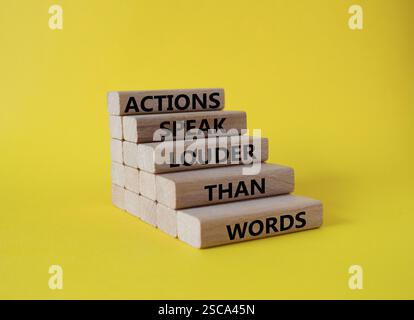 Taten sprechen lauter als Wörter. Holzblöcke mit Worten Aktionen sprechen lauter als Worte. Schöner gelber Hintergrund. Unternehmen und Aktionen Co Stockfoto