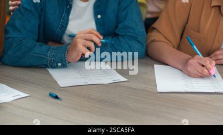 Unerkennbare Bildausschnitte aus der Nähe der Schule Kaukasische Schüler lernen Schüler lernen männliche Frauen lernen Hausaufgaben schreiben Teamarbeit am Tisch lernen Männer lernen Stockfoto