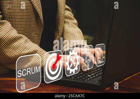 Scrum Prozesssoftware-Entwicklungskonzept. SCRUM, Konzept der agilen Entwicklungsmethodik. Geschäftsmann, der ein Notebook mit SCRUM-Symbolen auf dem virtuellen Bildschirm verwendet Stockfoto