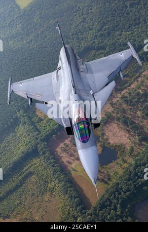 Eine ungarische Luftwaffe Saab JAS 39 Gripen, die während eines Air-Air-Fotoshootings einen Hochgeschwindigkeitspass durchführt. Der Gripen ist ein multifunktionaler Kampfflugzeug, das von mehreren Luftstreitkräften weltweit eingesetzt wird und mit dem Volvo RM12-Motor angetrieben wird. Stockfoto