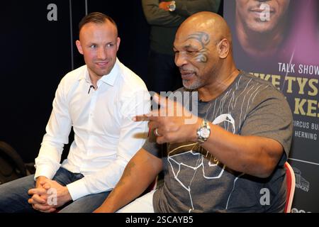 Mikkel Kessler & Mike Tyson in Kopenhagen Michael Gerard Tyson (* 30. Juni 1966 in Kopenhagen) ist ein ehemaliger US-amerikanischer Boxer, der von 1985 bis 2005 teilnahm. Er regierte als unangefochtener Weltmeister im Schwergewicht und hält den Rekord als jüngster Boxer, der mit 20 Jahren, vier Monaten und 22 Tagen einen Titel im Schwergewicht gewann.[5] Tyson gewann seine ersten 19 Profikämpfe durch Knockout oder Stop, 12 davon in der ersten Runde. 1986 gewann er den WBC-Titel, nachdem er Trevor Berbick in der zweiten Runde besiegt hatte, und ergänzte die WBA- und IBF-Titel, nachdem er 1987 James Smith und Tony Tucker besiegt hatte. Dies Stockfoto