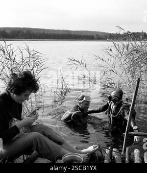 Taucher am See in Limsdorf Grubensee. Bild zeigt eine Frau stricken und Taucher im Wasser. Stockfoto