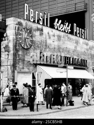 „Berliner Bahnhof Zoo“. Das Bild zeigt Menschen, ein Geschäft („Dr. E. Kuhlmann“) und Werbung an der Wand („Persil bleibt Persil“, Persil bleibt Persil). Stockfoto