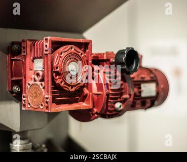 Industrielle Pumpengetriebe: Markante rote industrielle Pumpengetriebe mit komplizierter Mechanik und robustem Design, geeignet für Industrie- und Ingenieurthemen Stockfoto