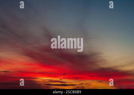 Der Himmel vor Sonnenuntergang, die Sonne malte die niedrigen Wolken in ein helles Rot. Stockfoto
