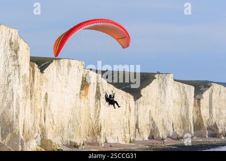 Eine Person fliegt mit einem Fallschirm über die Kreidefelsen der Sieben Schwestern in East Sussex, Großbritannien Stockfoto