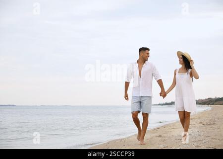 Schönes Paar, das am Strand spaziert. Platz für Text Stockfoto