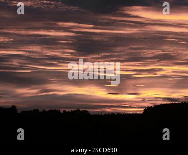 Ein atemberaubender Sonnenuntergangshimmel voller dramatischer Wolkenformationen und warmer Goldtöne Stockfoto