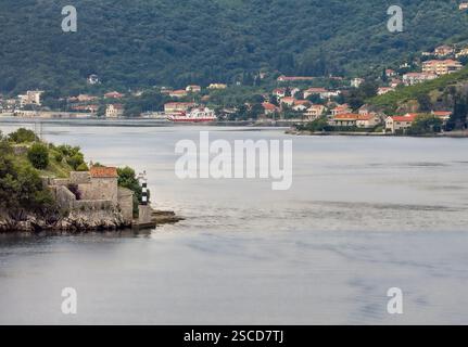 Bucht von Kotor, Montenegro - 2. Juli 2024: Kirche unserer Lieben Frau der Engel und ihr Leuchtfeuer, von Norden aus gesehen. Herceg Novi Gemeindedorf mit fe Stockfoto