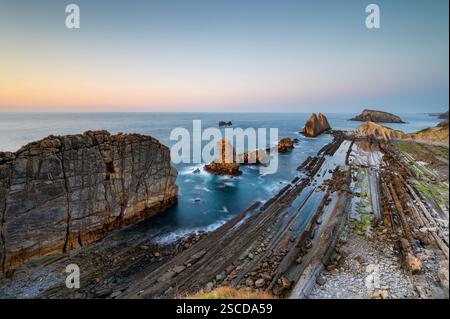 Dramatischer Blick auf Playa de la Arnia, Kantabrien, Spanien. Arnia Beach, Asturien bei Sonnenuntergang. Fantastische Landschaft, Linien, abstrakte Formen, schöne Farben. Stockfoto
