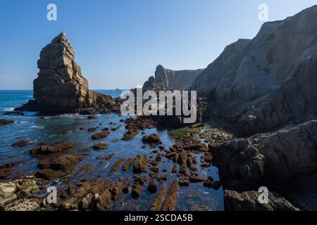 Dramatischer Blick auf Playa de la Arnia, Kantabrien, Spanien. Arnia Beach, Asturien bei Sonnenuntergang. Fantastische Landschaft, Linien, abstrakte Formen, schöne Farben. Stockfoto