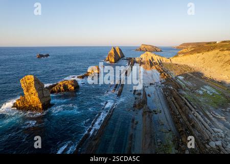 Dramatischer Blick auf Playa de la Arnia, Kantabrien, Spanien. Arnia Beach, Asturien bei Sonnenuntergang. Fantastische Landschaft, Linien, abstrakte Formen, schöne Farben. Stockfoto