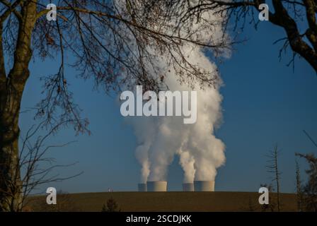 Grosse Schornsteine mit weißem Rauch am winterlichen Sonnentag in der Nähe des Kernkraftwerks in Südböhmen Stockfoto