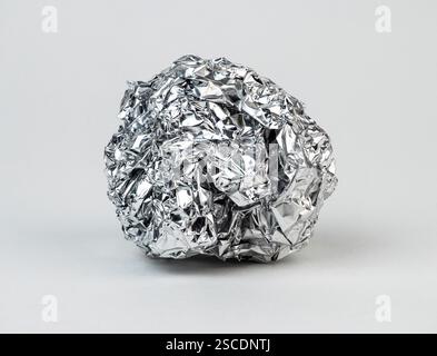 Zerknitterte Aluminiumfolie auf einer glatten Oberfläche Stockfoto