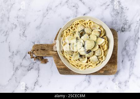Spaghetti mit Vongole Venusmuscheln, in Sahnesauce, Carbonara, auf einem Marmortisch, hausgemacht, Blick von oben, keine Leute Stockfoto