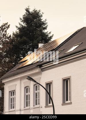 Solarpaneele bei Sonnenuntergang auf dem Dach eines Einfamilienhauses in Düsseldorf, Deutschland, Europa Stockfoto