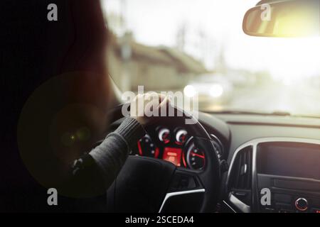 Blick aus dem Fahrzeuginnenraum, fokussiert auf das Armaturenbrett und die Straße vor dem Fahrzeug bei schlechten Lichtverhältnissen Stockfoto
