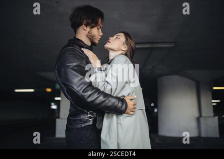 Ein Paar in enger Nähe in einer schwach beleuchteten unterirdischen Umgebung Stockfoto