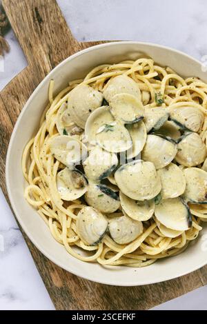 Spaghetti mit Vongole Venusmuscheln, in Sahnesauce, Carbonara, auf einem Marmortisch, hausgemacht, Blick von oben, keine Leute Stockfoto