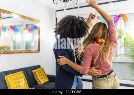 Vielfältige und multiethnische Freunde tanzen auf der Heimfeier von hinten zusammen lateinische Musik Stockfoto