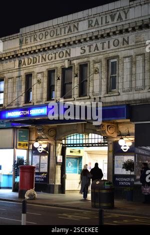 Der Eingang zur Metropolitan Railway an der Paddington Station, London, fotografiert bei Nacht, wenn zwei Personen betreten. Stockfoto