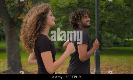 Indischer Mann Kaukasische Frau multirassisches Paar Freunde Mädchen Guy glücklicher Sport Menschen Athleten laufen zusammen im Park draußen Morgenlauf Jog gesund Stockfoto
