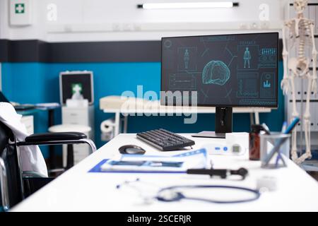 Leerer Klinikraum mit Computerbildschirm für Gehirn- und Körperscans, Schwerpunkt Neurologie und Computertomographie. Ärzteschalter mit medizinischen Akten und modernen Geräten ist bereit für die Gesundheitsanalyse. Stockfoto